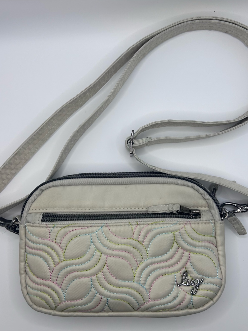 Lug Cream quilted crossbody bag with wave-like stitching and adjustable strap